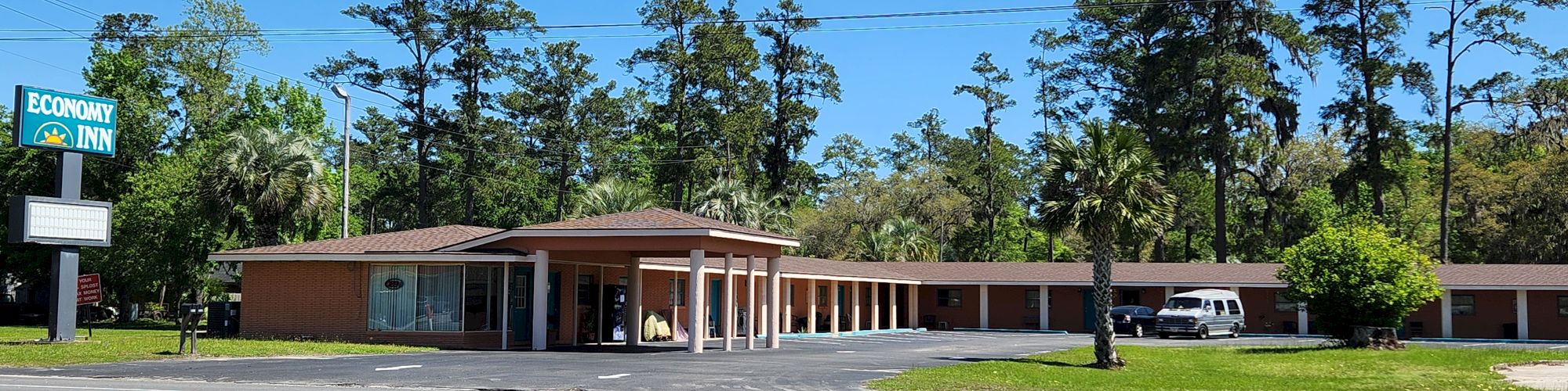 The image shows a roadside inn with a sign that says 