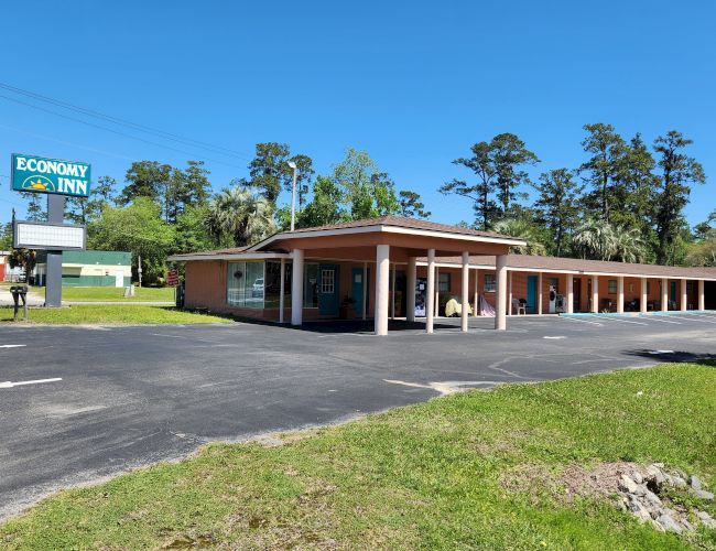 The image shows a single-story motel with a sign reading 